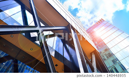 Steel and glass. The subject of modern architecture or construction industry. Modern office building facade with tall steel construction elements and full height windows between. Steel and glass. The subject of modern architecture or construction industry. Modern office building facade with tall steel construction elements and full height windows between. 140448935