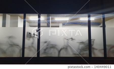Bicycles Behind Frosted Glass Silhouettes In Indoor Bike Parking With Motion Blur At Night Bicycles Behind Frosted Glass Silhouettes In Indoor Bike Parking With Motion Blur At Night 140449011