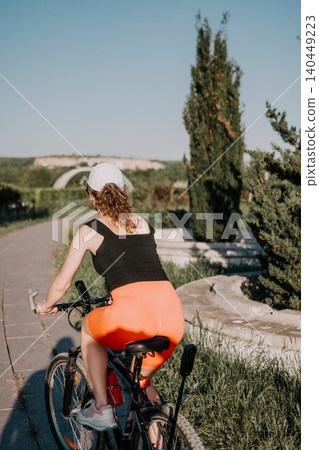 Bicycle cycling active woman riding mountain bike on sunny park path enjoying outdoor fitness activity with copy space for wellness text Bicycle cycling active woman riding mountain bike on sunny park path enjoying outdoor fitness activity with copy space for wellness text 140449223