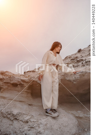 Woman desert outdoors standing on white rock formations during a peaceful sunset with copy space Woman desert outdoors standing on white rock formations during a peaceful sunset with copy space 140449228
