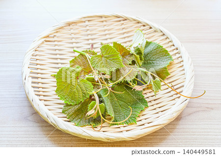 New shoots of wild mountain grapes served in a basket 140449581