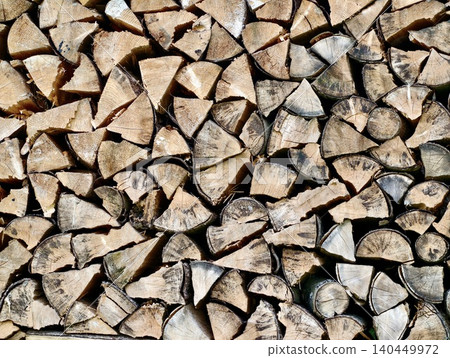 Stacked split firewood pile with natural bark and cut ends 140449972