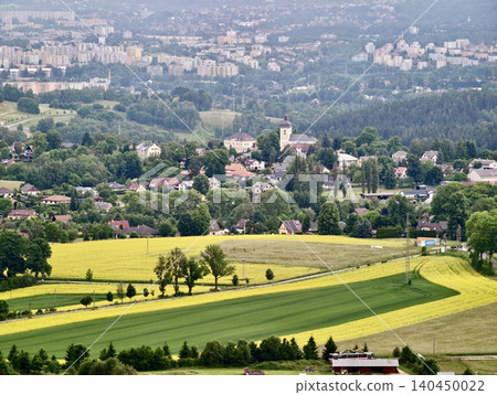 Rural hillside village with patchwork fields and distant city skyline Rural hillside village with patchwork fields and distant city skyline 140450022