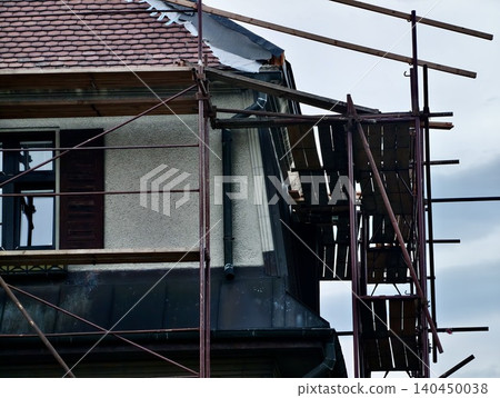 Exterior house renovation with scaffolding and tiled roof Exterior house renovation with scaffolding and tiled roof 140450038