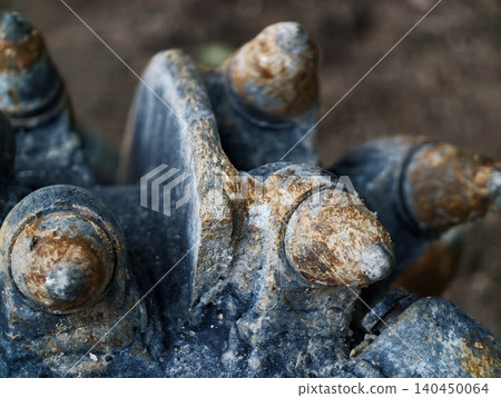 Close-up of weathered metal gear with rusted studs 140450064
