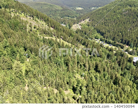 Aerial view of dense evergreen forest on rolling mountain slopes Aerial view of dense evergreen forest on rolling mountain slopes 140450094