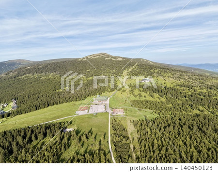 Mountain ridge resort buildings surrounded by forested slopes Mountain ridge resort buildings surrounded by forested slopes 140450123