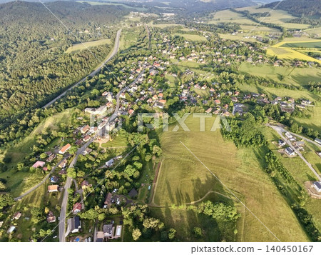 Aerial view of rural village with fields and winding road in green countryside Aerial view of rural village with fields and winding road in green countryside 140450167