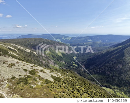 Wide panoramic mountain valley with forested slopes under clear sky Wide panoramic mountain valley with forested slopes under clear sky 140450269