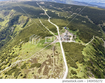 Aerial view of mountain ridge trails and small alpine building 140450272