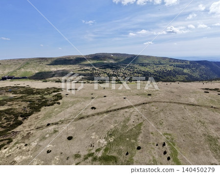 Wide elevated view of windswept upland moor and distant rolling hills under blue sky Wide elevated view of windswept upland moor and distant rolling hills under blue sky 140450279