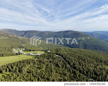 Aerial view of mountain valley with forested slopes and rural homestead Aerial view of mountain valley with forested slopes and rural homestead 140450280
