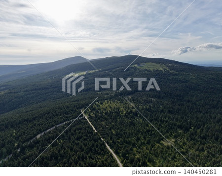 Aerial view of forested mountain ridgeline with winding trail Aerial view of forested mountain ridgeline with winding trail 140450281