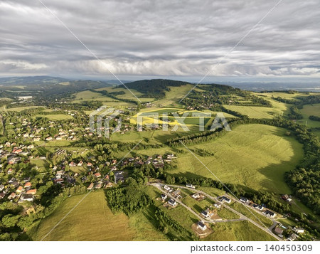 Aerial view of rolling green countryside with village and farmland Aerial view of rolling green countryside with village and farmland 140450309
