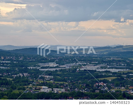 Panoramic view of a small town in a green valley under cloudy sky 140450323
