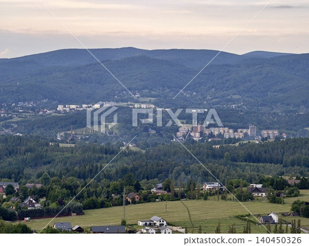 Hillside town and surrounding farmland under soft evening sky 140450326