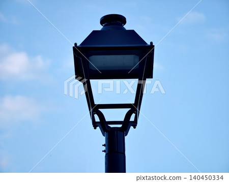 Black street lantern silhouette against blue sky Black street lantern silhouette against blue sky 140450334