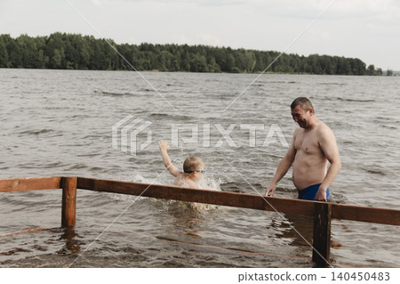 dynamic, relaxed shot boy jumping into natural lake. child is captured mid flight, creating sense excitement. image perfect family vacations, water safety, promoting active lifestyle among children dynamic, relaxed shot boy jumping into natural lake. child is captured mid flight, creating sense excitement. image perfect family vacations, water safety, promoting active lifestyle among children 140450483
