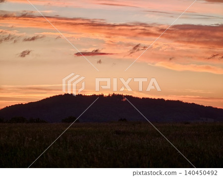 Sunset sky over dark hillside landscape Sunset sky over dark hillside landscape 140450492