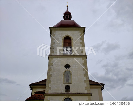 Historic church tower with clock against cloudy sky Historic church tower with clock against cloudy sky 140450496
