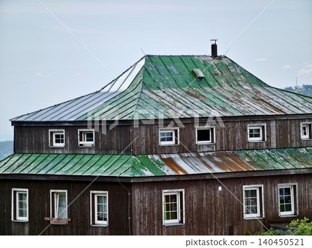 Weathered wooden house with green metal roof Weathered wooden house with green metal roof 140450521