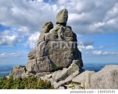 Towering granite rock formation under dramatic cloudy sky Towering granite rock formation under dramatic cloudy sky 140450545