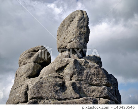 Weathered rock formation against a cloudy sky Weathered rock formation against a cloudy sky 140450546