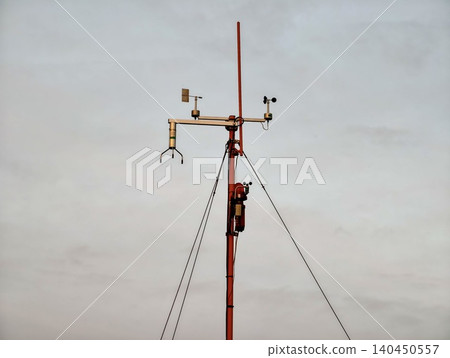 Weather monitoring mast with instruments against cloudy sky Weather monitoring mast with instruments against cloudy sky 140450557