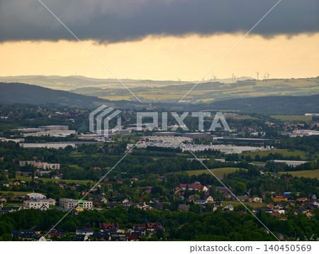 Storm clouds over a rural valley with hills, fields, villages, and wind turbines Storm clouds over a rural valley with hills, fields, villages, and wind turbines 140450569