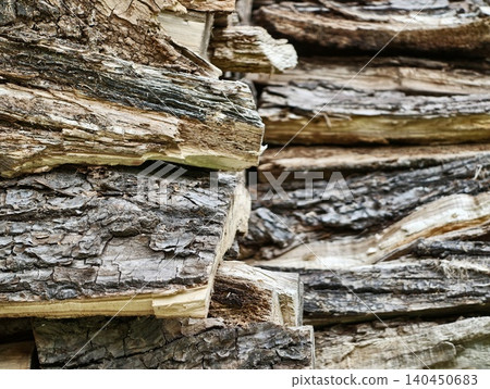 Stack of split firewood with rough bark texture 140450683