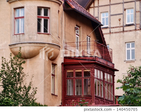 Historic European townhouse with enclosed wooden balcony and stucco facade Historic European townhouse with enclosed wooden balcony and stucco facade 140450705