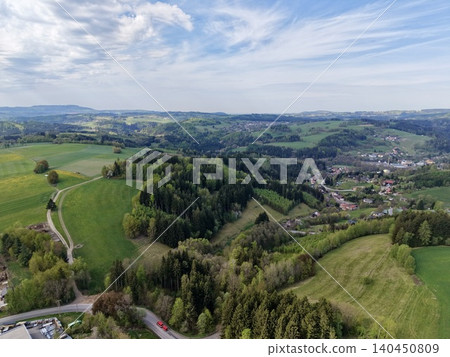 Idyllic Rural Roadway Stretching Towards Quaint Settlement Amid Rolling Hills And Expansive Skies Idyllic Rural Roadway Stretching Towards Quaint Settlement Amid Rolling Hills And Expansive Skies 140450809