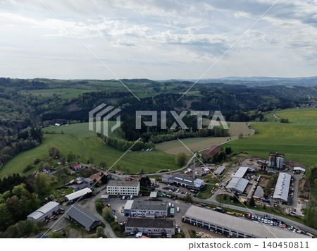 Distribution Centers Amid Rural Landscape. Commercial Zone Set Against Lush Green Hills And Fields Distribution Centers Amid Rural Landscape. Commercial Zone Set Against Lush Green Hills And Fields 140450811