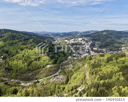 Winding Woodland Road Through Trees. Overhead Perspective Of Twisting Forest Route With Village Views Winding Woodland Road Through Trees. Overhead Perspective Of Twisting Forest Route With Village Views 140450815