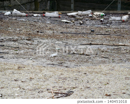 Trashcovered Shoreline Amid Nature. Neglected Coastal Area Filled With Debris And Environmental Hazards Trashcovered Shoreline Amid Nature. Neglected Coastal Area Filled With Debris And Environmental Hazards 140451018