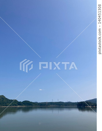 The clear blue sky and the scenery reflected on the water's surface The clear blue sky and the scenery reflected on the water's surface 140451308