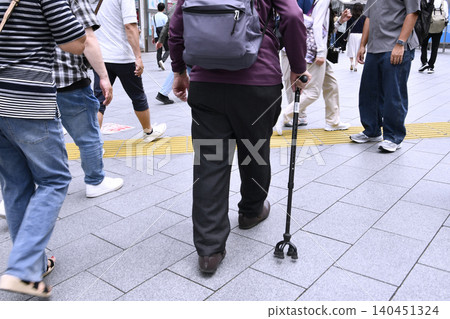 An elderly man with a cane walks through the streets of Shibuya, Tokyo, Japan... an aging society... = 13th 140451324