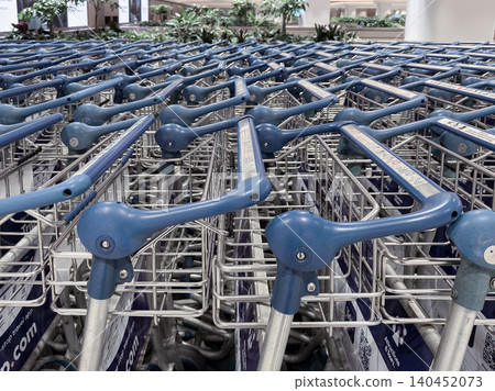Multiple shopping carts lined up at Changi Airport in Singapore ready for travelers Multiple shopping carts lined up at Changi Airport in Singapore ready for travelers 140452073