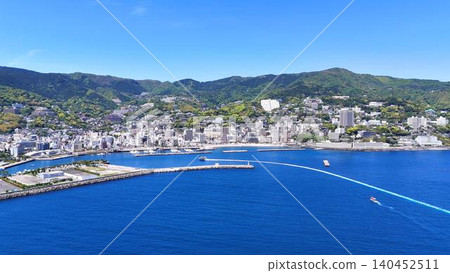 Panoramic aerial view of Atami's hot spring resort town and Sagami Bay | Ship's wake Panoramic aerial view of Atami's hot spring resort town and Sagami Bay | Ship's wake 140452511
