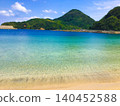 一片靜謐的沙灘，四周環繞著清澈的海水和山脈。 140452588