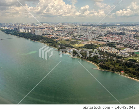 Aerial view of the coastline and urban landscape of Singapore with clouds in the sky Aerial view of the coastline and urban landscape of Singapore with clouds in the sky 140453042