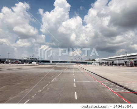 Changi Airport runway with clouds and terminal buildings 140453043