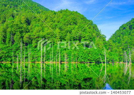 初夏清晨，陽光明媚：綿延至天然湖泊上游的層疊山脈，倒映在水中，宛如達摩不倒翁。 140453077