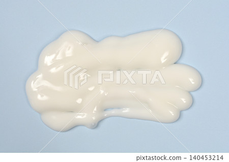 Top view of white cosmetic cream swatch on blue background Top view of white cosmetic cream swatch on blue background 140453214