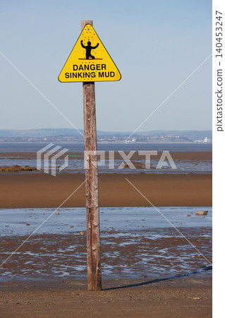 Bright yellow sinking mud warning sign on beach Bright yellow sinking mud warning sign on beach 140453247