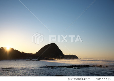 Sunrise over a big rock by the sea Sunrise over a big rock by the sea 140453340