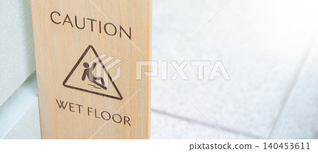 Wet Floor Caution sign with slippery man symbol. Signboard made from wooden board 140453611