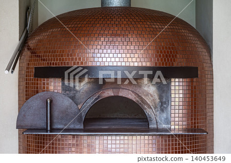 Empty modern wood fire pizza oven covered with copper bronze mosaic tiles Empty modern wood fire pizza oven covered with copper bronze mosaic tiles 140453649