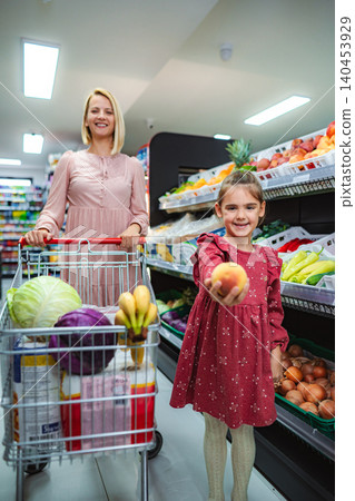Mother and daughter buying fresh fruit in grocery store Mother and daughter buying fresh fruit in grocery store 140453929