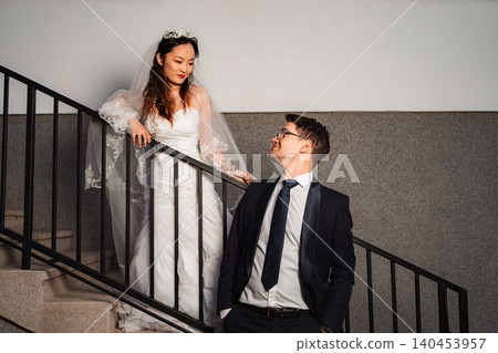 Interracial wedding couple on stairs sharing special loving mome Interracial wedding couple on stairs sharing special loving mome 140453957